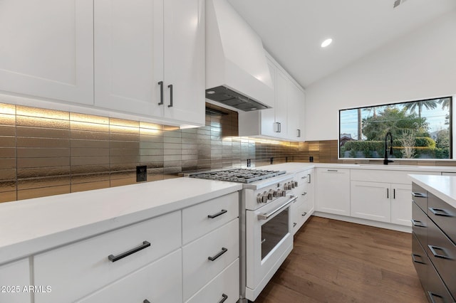 kitchen with custom exhaust hood, light countertops, white cabinets, a sink, and high end white range