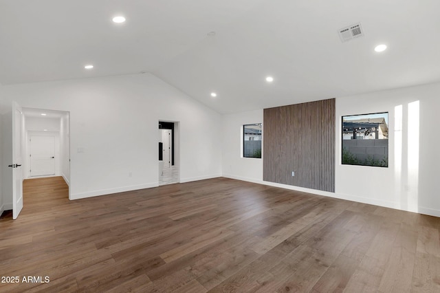 spare room featuring recessed lighting, wood finished floors, visible vents, baseboards, and vaulted ceiling