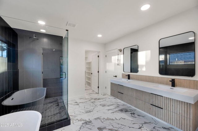 bathroom with marble finish floor, double vanity, a freestanding bath, a sink, and a shower stall