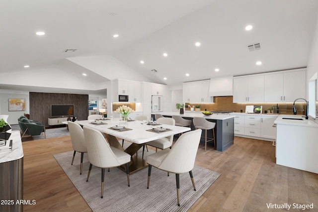 dining room featuring recessed lighting, visible vents, vaulted ceiling, and light wood-style flooring