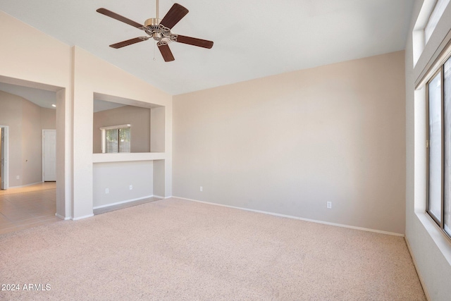 carpeted spare room featuring plenty of natural light, lofted ceiling, and ceiling fan