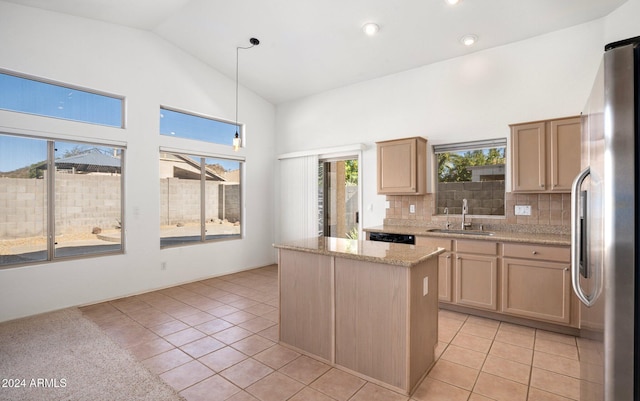 kitchen featuring hanging light fixtures, a wealth of natural light, sink, and stainless steel refrigerator with ice dispenser