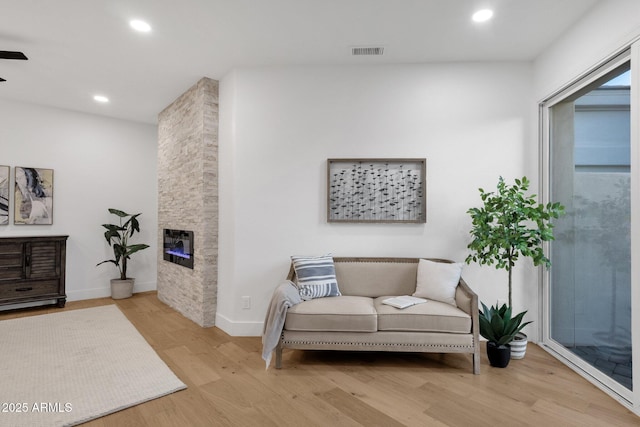 sitting room with a fireplace, recessed lighting, visible vents, wood finished floors, and baseboards