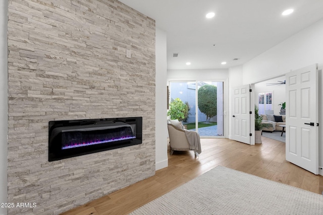 interior space featuring recessed lighting, visible vents, a stone fireplace, and wood finished floors