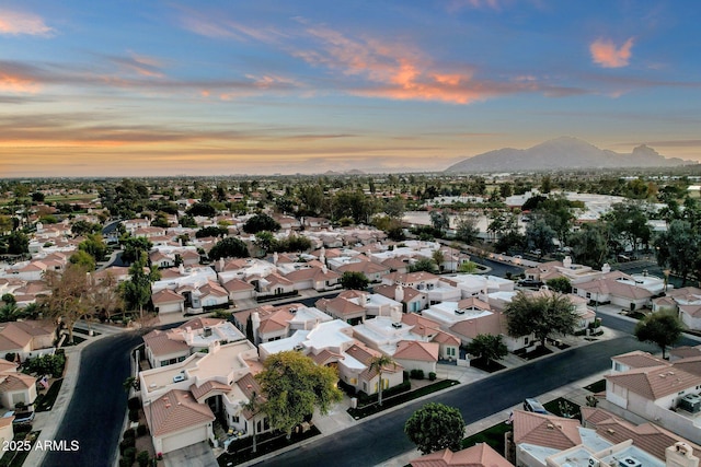 aerial view at dusk featuring a residential view and a mountain view