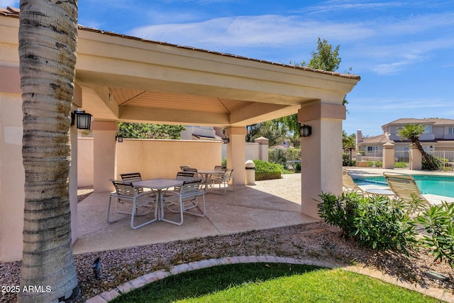 view of patio / terrace featuring a gazebo, outdoor dining area, fence, and a fenced in pool