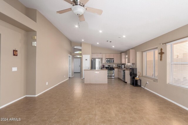 unfurnished living room with sink, light tile patterned floors, vaulted ceiling, and ceiling fan