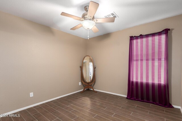 unfurnished room featuring ceiling fan and dark wood-type flooring