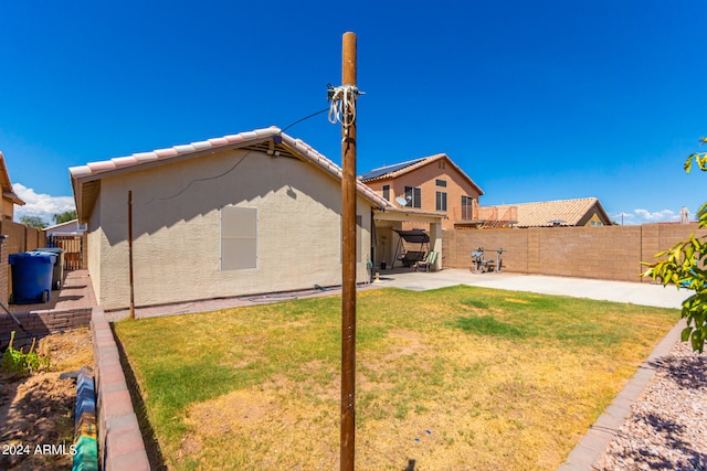 rear view of house with a patio area and a lawn