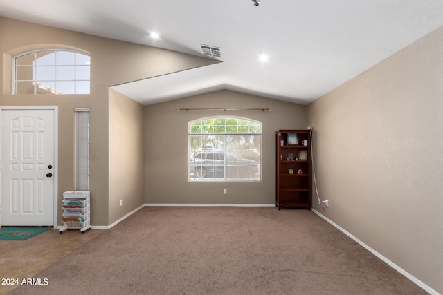 entrance foyer with carpet flooring and vaulted ceiling