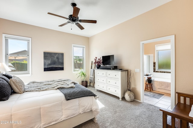 bedroom featuring light carpet, ceiling fan, and ensuite bathroom