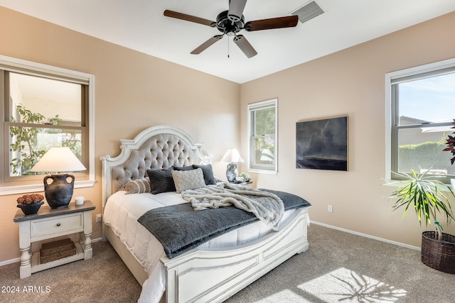 carpeted bedroom with multiple windows and ceiling fan