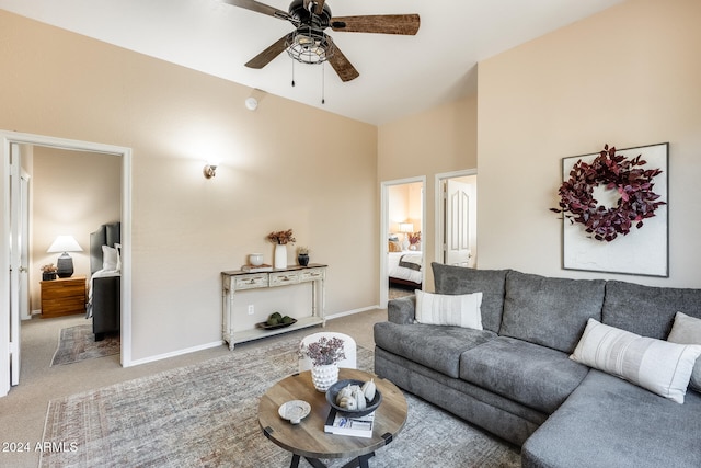 carpeted living room with ceiling fan and high vaulted ceiling