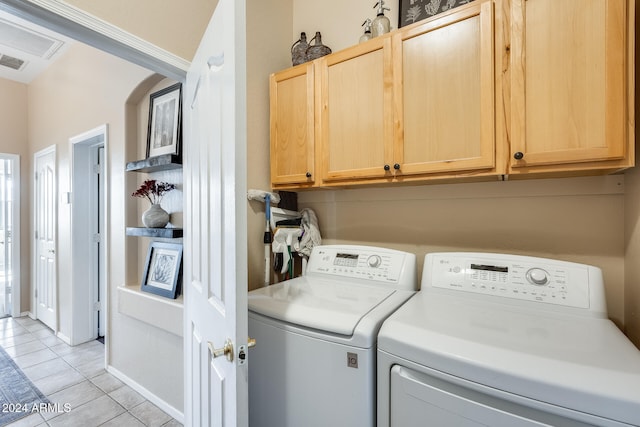 washroom with cabinets, separate washer and dryer, and light tile patterned floors