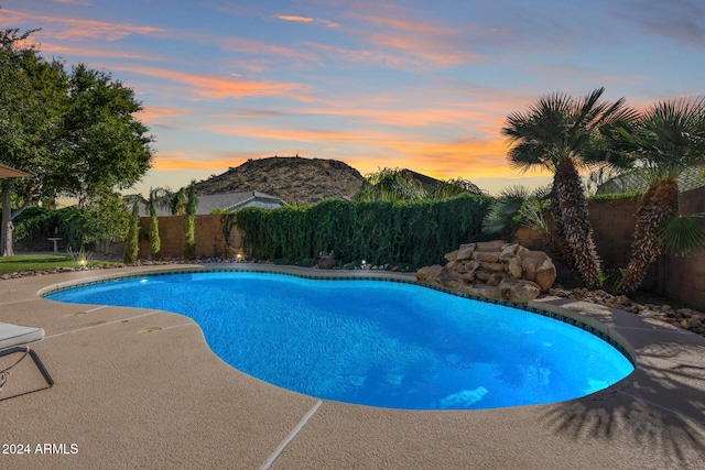 pool at dusk with a patio