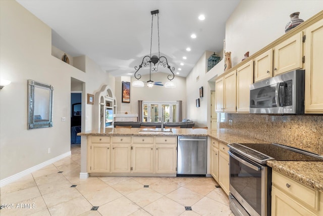 kitchen with light tile patterned floors, appliances with stainless steel finishes, hanging light fixtures, tasteful backsplash, and kitchen peninsula