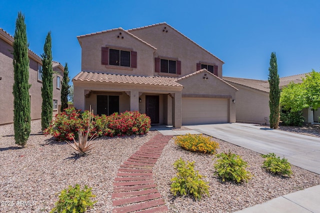 mediterranean / spanish-style home with concrete driveway, a tiled roof, an attached garage, and stucco siding