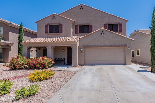 mediterranean / spanish house with a garage, concrete driveway, a tiled roof, and stucco siding