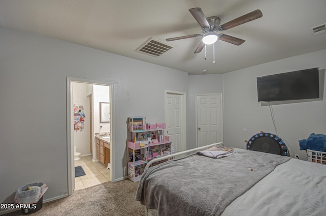 bedroom featuring ceiling fan, ensuite bath, and light carpet