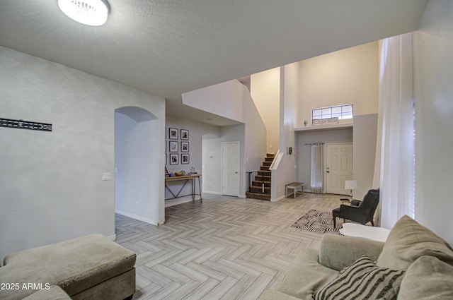 living room featuring light parquet flooring and a towering ceiling