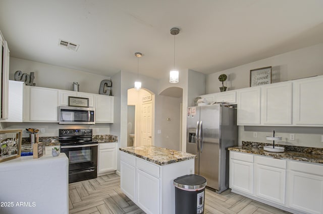 kitchen with stainless steel appliances, a center island, pendant lighting, light parquet flooring, and white cabinets