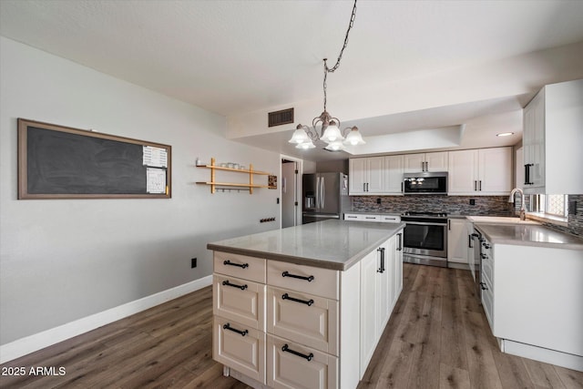 11621 N 39th Dr, Phoenix, AZ 85029 - kitchen with an inviting chandelier, tasteful backsplash, visible vents, wood finished floors, and stainless steel appliances