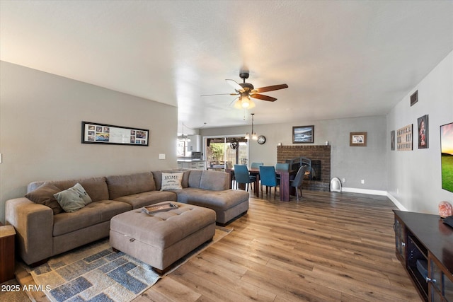 11621 N 39th Dr, Phoenix, AZ 85029 - living area featuring ceiling fan, a fireplace, visible vents, wood finished floors, and baseboards