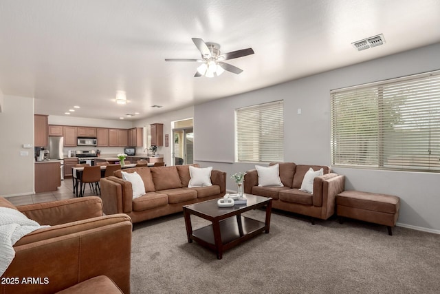 living room featuring ceiling fan and light colored carpet