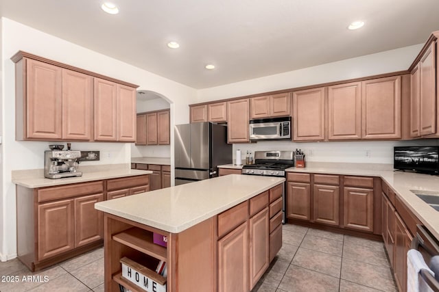 kitchen featuring sink, appliances with stainless steel finishes, a kitchen island, and light tile patterned flooring