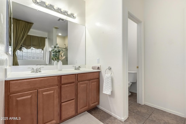 bathroom with vanity, toilet, and tile patterned floors