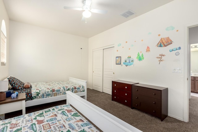 bedroom featuring ceiling fan, dark colored carpet, and a closet