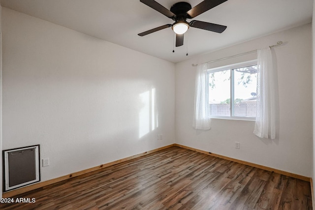 empty room with dark hardwood / wood-style flooring and ceiling fan