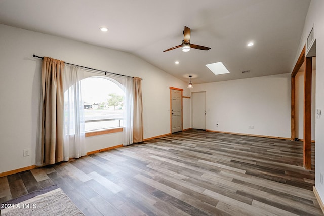 interior space featuring lofted ceiling with skylight, ceiling fan, and wood-type flooring