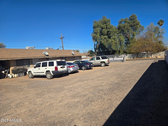 uncovered parking lot featuring fence