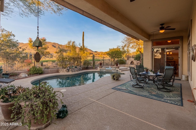 view of swimming pool with a mountain view, a patio, and ceiling fan