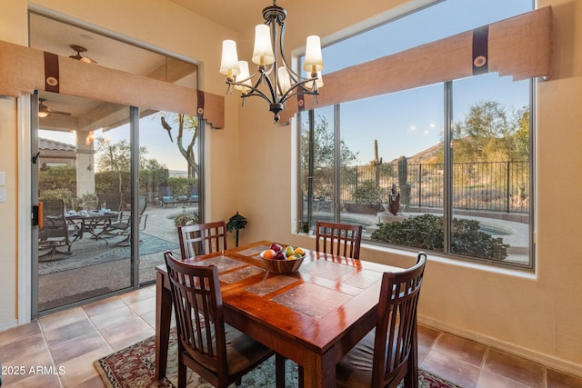 dining room with tile patterned flooring, a wealth of natural light, and a chandelier