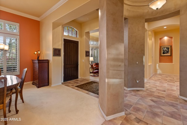 entrance foyer with crown molding, a towering ceiling, and light carpet