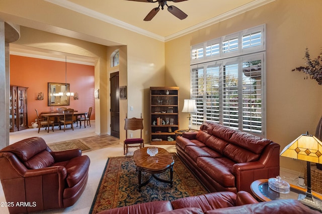 carpeted living room with ceiling fan with notable chandelier and ornamental molding