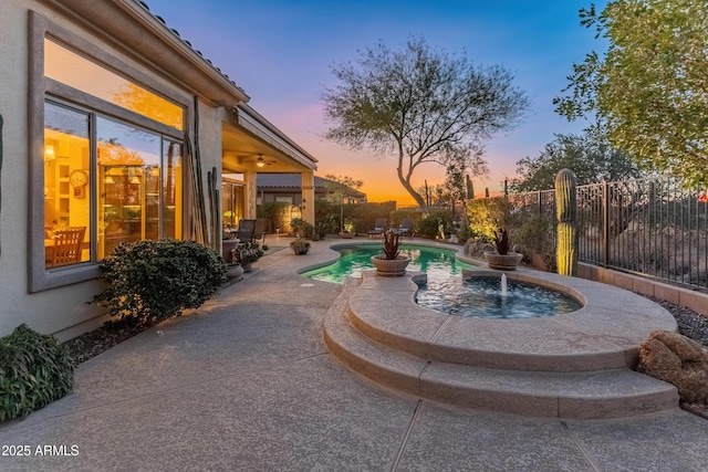 pool at dusk featuring a patio