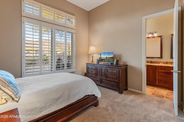 bedroom with light colored carpet and connected bathroom