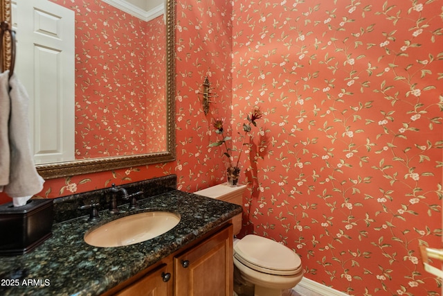 bathroom with vanity, crown molding, and toilet