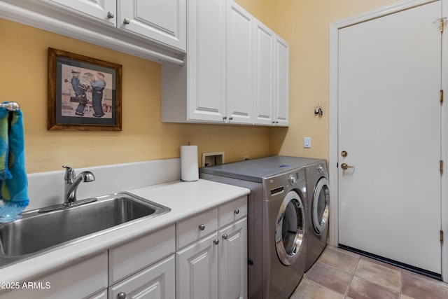 washroom with sink, light tile patterned floors, washer and clothes dryer, and cabinets