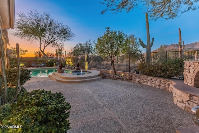 patio terrace at dusk with a fenced in pool