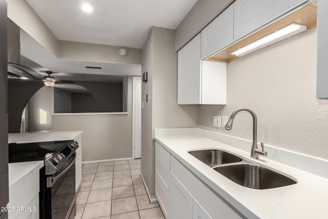 14408 N 35th Ave, Phoenix, AZ 85053 - kitchen with light tile patterned flooring, sink, white cabinetry, electric range, and wall chimney range hood
