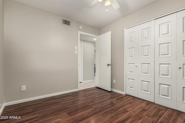 14408 N 35th Ave, Phoenix, AZ 85053 - unfurnished bedroom featuring dark wood-type flooring, ceiling fan, and a closet
