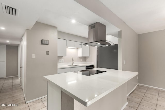 kitchen with a kitchen island, island range hood, white cabinetry, sink, and black electric stovetop