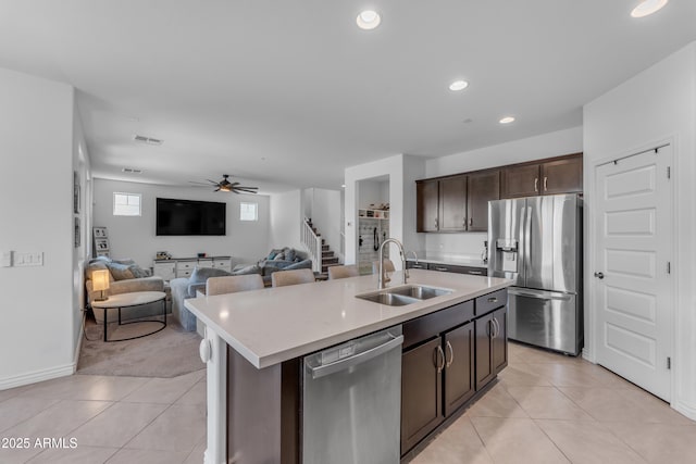 12370 W Cassia Trl, Peoria, AZ 85383 - kitchen featuring stainless steel appliances, a sink, light tile patterned floors, dark brown cabinetry, and recessed lighting