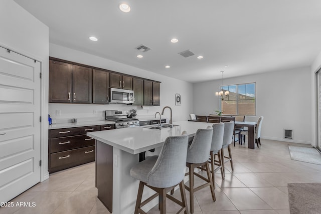 12370 W Cassia Trl, Peoria, AZ 85383 - kitchen featuring stainless steel appliances, a sink, a kitchen breakfast bar, an island with sink, and light countertops