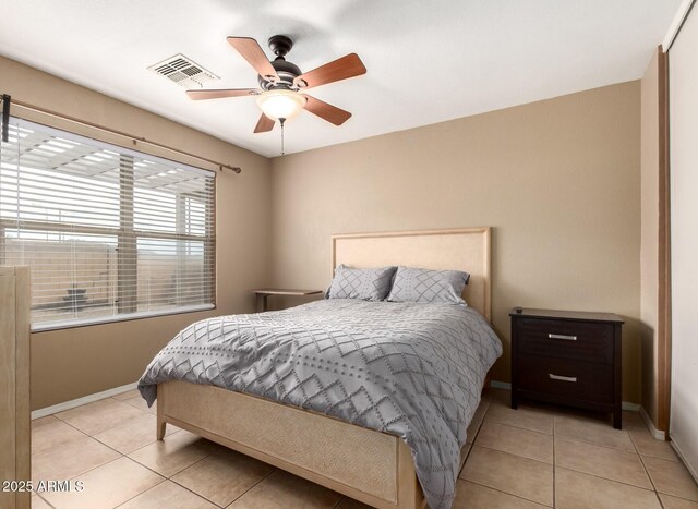 tiled bedroom featuring ceiling fan