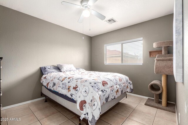 bedroom featuring ceiling fan, light tile patterned flooring, and a textured ceiling